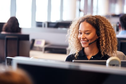 Woman with headset providing customer support, representing managed services and remote assistance.