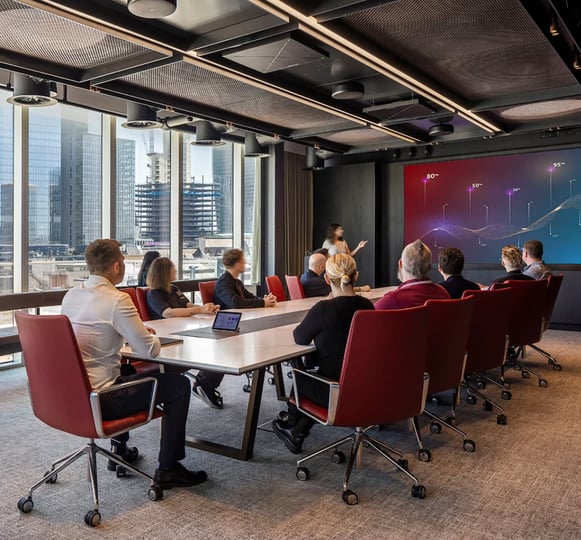 Employees collaborating in a technology-enabled meeting room, showcasing Yorktel and Kinly’s 40-year legacy of empowering digital workplaces and unified communications solutions.
